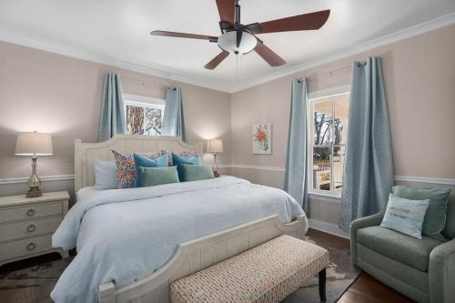 um quarto com uma cama, uma ventoinha de tecto e uma cadeira em Vino Vida spacious home with hot tub em Fredericksburg