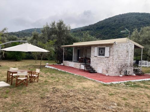 a small house with a table and an umbrella at Helios Beach House in Mikros Gialos
