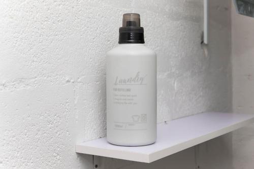 a white bottle sitting on a shelf next to a wall at ガジュマルの庭～itoman in Ō