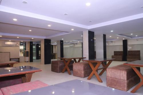 a lobby with tables and stools in a building at TRP Rama Inn in Gwalior