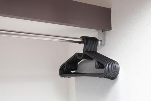 a black shower curtain holder on a wall at ガジュマルの庭～itoman in Ō