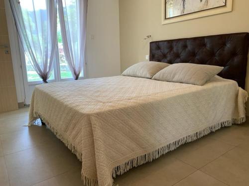a large bed in a bedroom with a large window at VILLA PETRETO in Petreto-Bicchisano