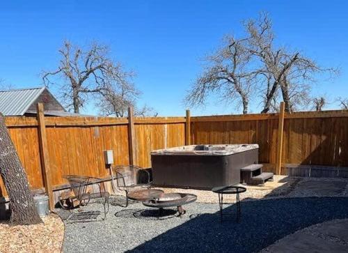 a backyard with a hot tub and chairs and a fence at Das Jager Haus Secluded Cabin pet friendly in Fredericksburg