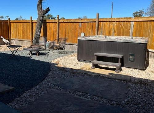 a backyard with a barbecue and a bench and a fence at Das Jager Haus Secluded Cabin pet friendly in Fredericksburg