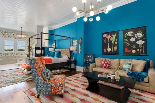 a living room with blue walls and a bed and a couch at The Loft on Main St loft with balcony views in Fredericksburg