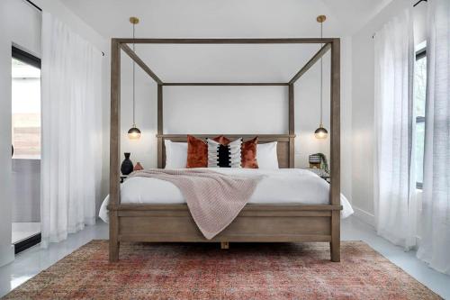 1 dormitorio con cama con dosel y alfombra en Getaway at Enchanted walk to Main Hot Tub, en Fredericksburg