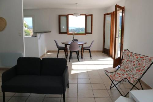 - un salon avec un canapé, une table et des chaises dans l'établissement Agréable villa - proche commodités mer et montagne, à Afa