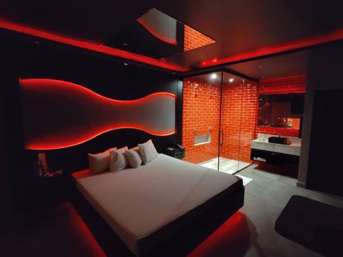 a bedroom with a white bed and red lighting at Motel Prestige in Sorocaba