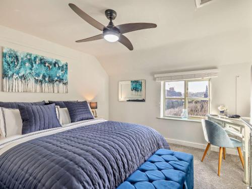 a bedroom with a blue bed and a ceiling fan at 5 Bed in Hoar Cross 94191 in Newborough