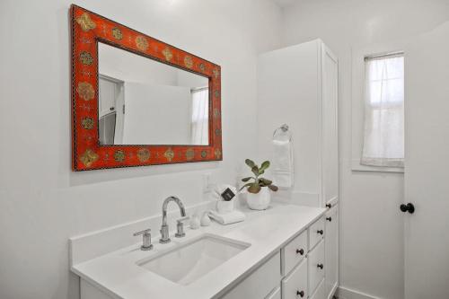 a white bathroom with a sink and a mirror at Cactus Coterie with Hot tub & pet friendly in Fredericksburg