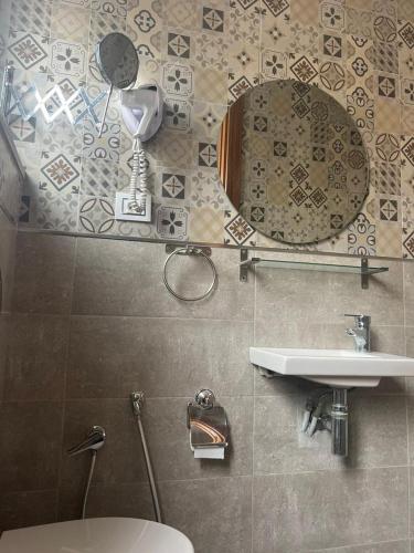 a bathroom with a sink and a mirror on the wall at Hotel Transatlantique Tunis in Tunis