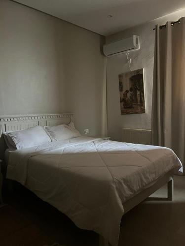 a white bed in a bedroom with a window at Hotel Transatlantique Tunis in Tunis