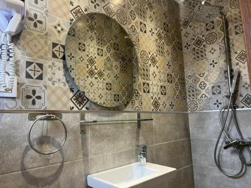 Hotel Transatlantique Tunis في تونس: حمام مع حوض ومرآة