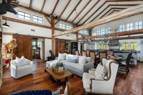 a large living room with white furniture and a kitchen at River Hill Ranch, great views & river access! in Flugrath