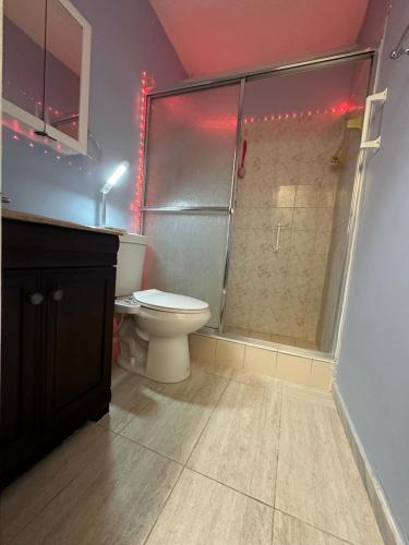 a bathroom with a toilet and a shower with red lights at Hidden MIA Apartment in Miami