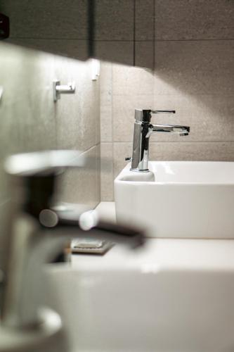 a bathroom sink with a faucet on top of it at Oiti Mountain Apartments in Pávliani