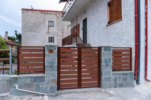 a wooden gate in front of a building at Oiti Mountain Apartments in Pávliani