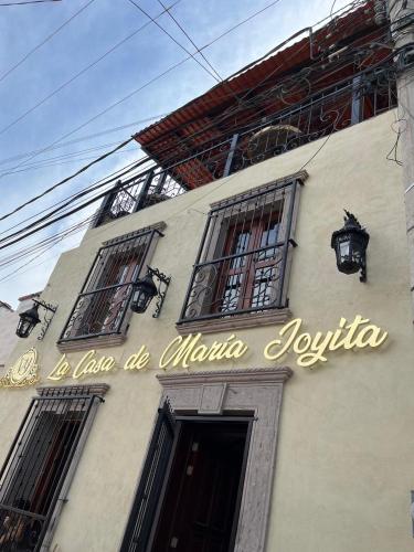 a sign on the side of a building with windows at Hotel La Casa de María Joyita in Aguascalientes
