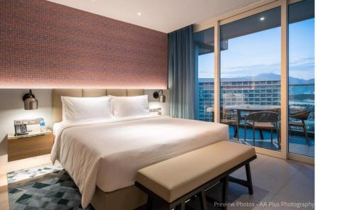 een slaapkamer met een groot bed en een balkon bij Alma Resort in Thôn Mỹ Ca