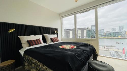 um quarto com uma cama grande e uma janela grande em ApartmentInCopenhagen Apartment 1613 em Copenhague