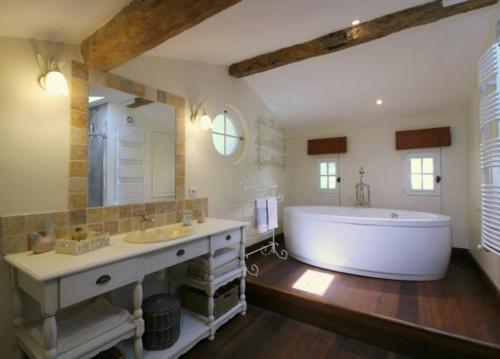 a large bathroom with a large tub and a sink at Chambre d'hôtes spacieuse, salle de bain privative in Saint-Michel-de-Fronsac