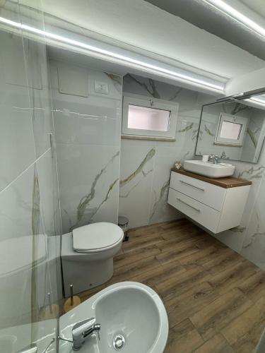 a bathroom with a toilet and a sink at Carmen’s house in Nettuno