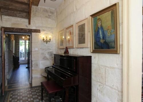 a room with a piano and a painting on a wall at Chambre d'hôtes spacieuse, salle de bain privative in Saint-Michel-de-Fronsac