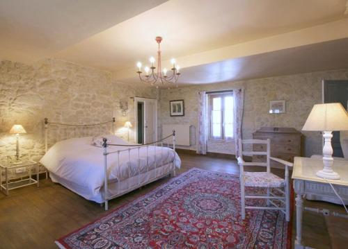 a bedroom with a bed and a table and a chair at Chambre d'hôtes spacieuse, salle de bain privative in Saint-Michel-de-Fronsac