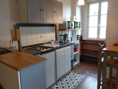 une cuisine avec des armoires blanches et un comptoir dans l'établissement STUDIO RDC au pied du château et balcon sur la vilaine, à Vitré