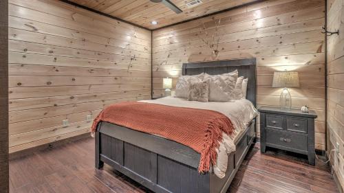 a bedroom with a bed and a wooden wall at Hawksnest in Mashburn Mill