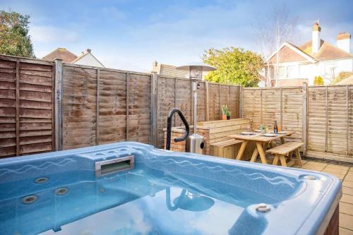 a swimming pool in a backyard with a wooden fence at Stunning 4br House for 10 Near Beach w Hot Tub in Bognor Regis
