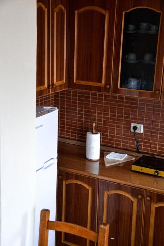 a kitchen with a refrigerator and a counter with chairs at Shkodër A&K in Shkodër