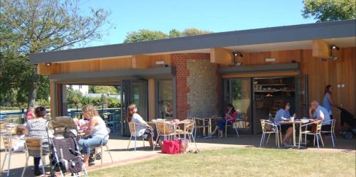 a group of people sitting at tables outside of a building at Stunning 4br House for 10 Near Beach w Hot Tub in Bognor Regis