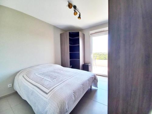 une chambre avec un lit et une grande fenêtre dans l'établissement Spacieux T3-Toit terrasse-Clim-wifi-piscine, à Fréjus