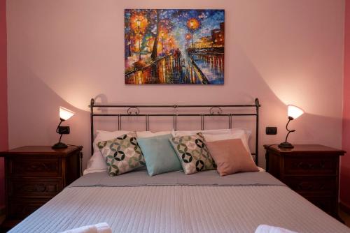um quarto com uma cama com um quadro na parede em Appartamento Talia em Bevagna