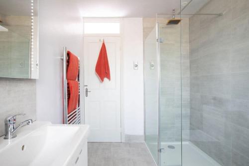 a bathroom with a shower and a sink and a tub at Bright & modern Sussex seafront home Great views in Selsey