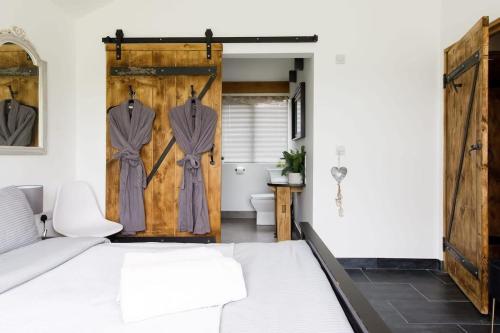a bedroom with a bed and a wooden door at Stylish Getaway Vast Courtyard Hot Tub in South Mundham
