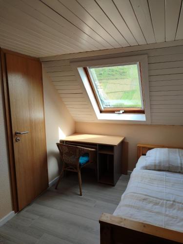 a bedroom with a desk and a window and a bed at Gästehaus Herda in Briedel