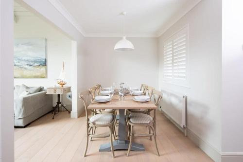 a dining room with a wooden table and chairs at Superior house for 6 near beach w parking garden in West Wittering