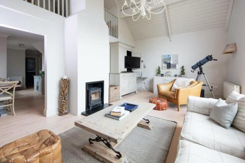 a living room with a white couch and a fireplace at Superior house for 6 near beach w parking garden in West Wittering