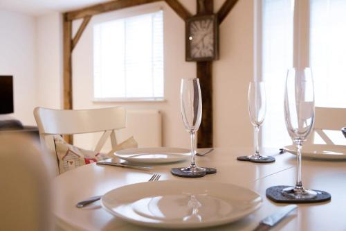 a table with wine glasses and plates on it at Idyllic countryside annexe near West Wittering beach in West Wittering