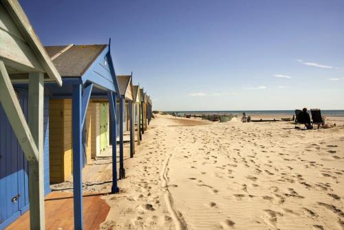 a row of beach houses on a sandy beach at Panoramic sea views in beachfront apt w balcony in Bognor Regis