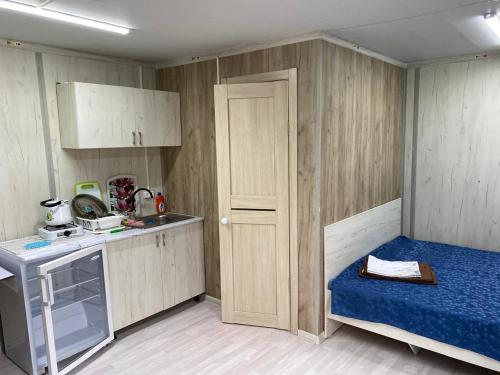 a small kitchen with a blue bed and a door at Module house - Burabay in Borovoye