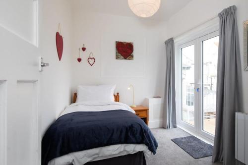 a bedroom with a bed and a window at Beautiful Beachfront House wth Balcony & Sea Views in Bognor Regis