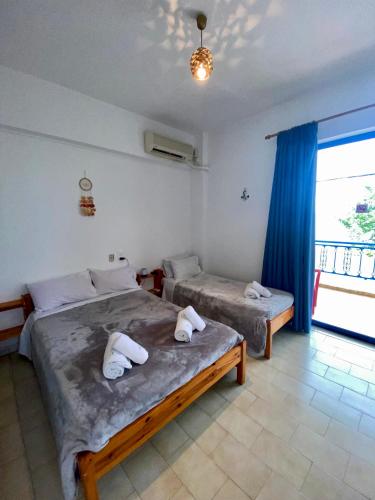 a bedroom with two beds and a large window at Alexandra Studios in Néos Pírgos