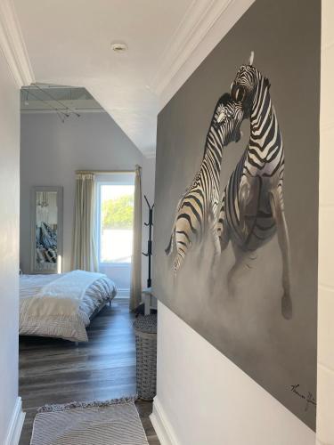 two zebras mural on the wall of a bedroom at Lasalle holiday home (Sun, Beach, Views, Fun for everyone!) in Plettenberg Bay