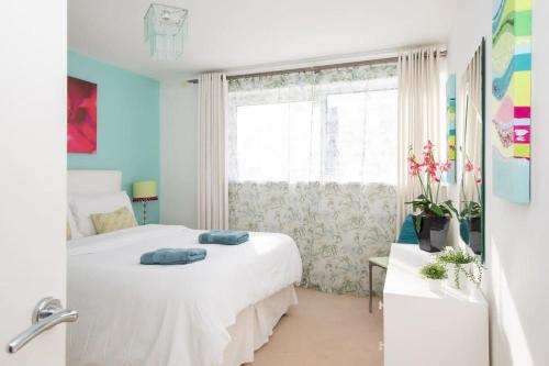 um quarto com uma cama branca e uma janela em Sunny & Modern Near the Beach & Village w Parking em East Wittering