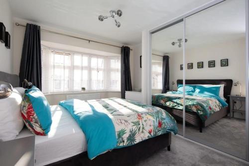 a bedroom with two beds and a large mirror at Charming & Modern City Escape Garden Parking in Chichester