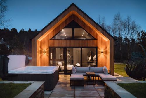 une maison avec un bain à remous et un canapé dans l'établissement Newlands Lodges, à Shotley Bridge