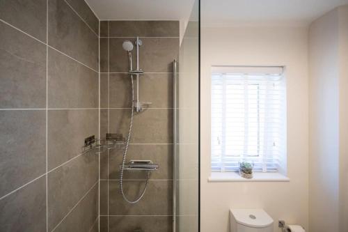 a bathroom with a shower with a glass door at Charming & Modern City Escape Garden Parking in Chichester